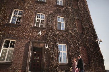 Genç düğün iki aşk hikayesi, gelin ve damat arka planda bina yakın poz sonra. Krakow