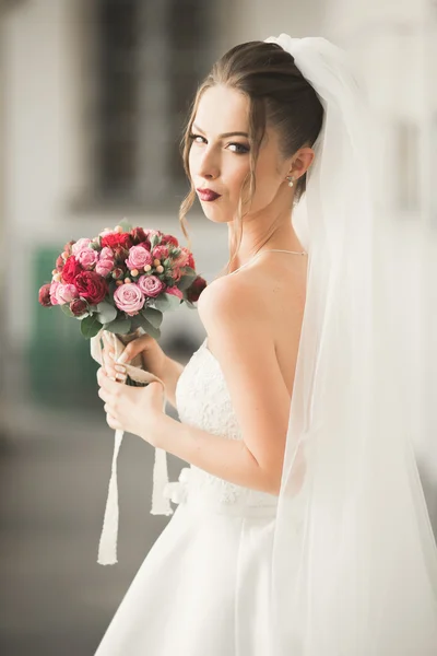 Bela noiva com bouquet de casamento posando na cidade velha — Fotografia de Stock