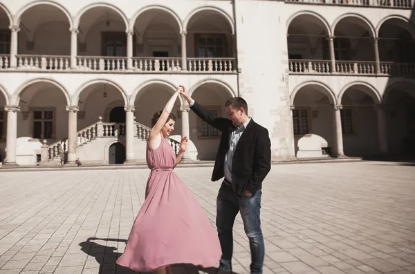 Красивая пара, мужик, девушка с длинным розовым платьем позирует в старом замке возле колонн. Вавель Кракова — стоковое фото