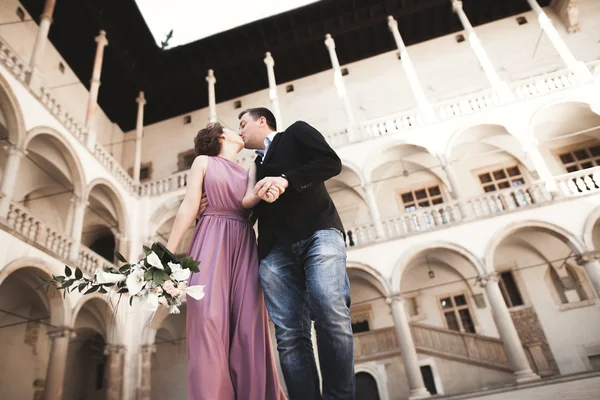 Bella coppia, uomo, ragazza con abito lungo rosa in posa nel vecchio castello vicino colonne. Vavello di Cracovia — Foto Stock