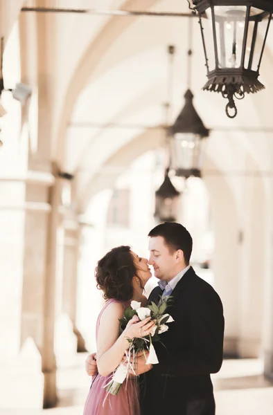 Pareja romántica de la boda, hombre y mujer, posando cerca de la columna del edificio viejo — Foto de Stock