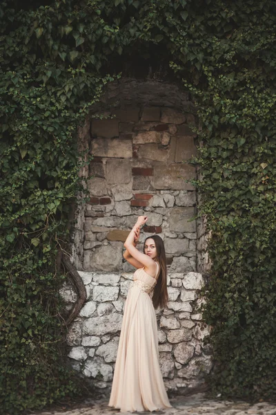 Красива дівчина, модель біля стіни листя і кущів в парку — стокове фото