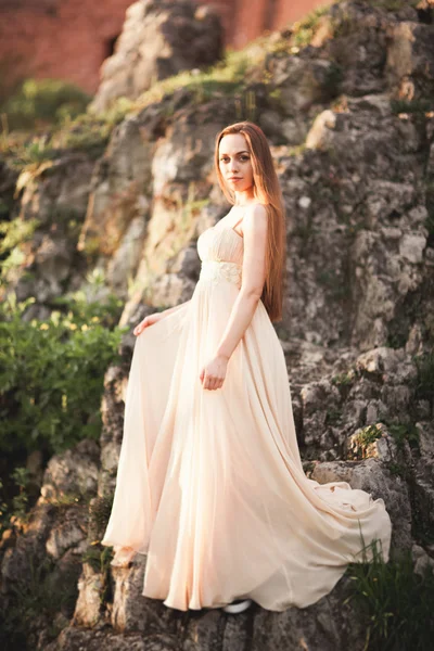 ロングドレス立っている岩の上に魅力的な若い女性 — ストック写真