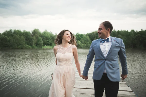 Menyasszony és a vőlegény, séta a folyón, mosolyogva, csók — Stock Fotó