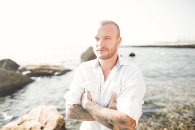 yakışıklı model adam taş denizin kenarında poz