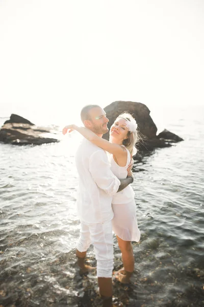 Просто одружена весільна пара, що йде на пляжі на заході сонця . — стокове фото