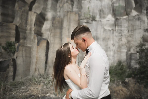 Schönes Hochzeitspaar in den Bergen mit Felsen — Stockfoto