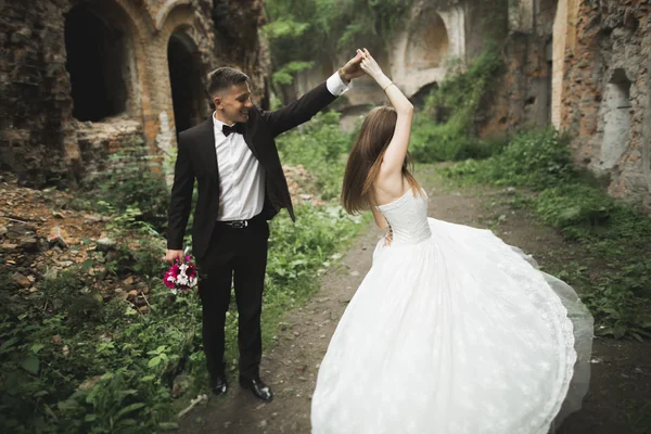 Bella coppia di sposi romantici che si abbracciano vicino al vecchio castello — Foto Stock