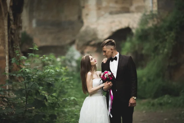 Šťastní novomanželé nedaleko starobylého hradu na procházku — Stock fotografie