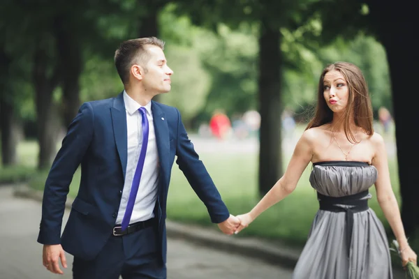 Unga vackra par, tjej med perfekta klänningen poserar i park — Stockfoto