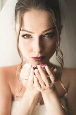 Beyaz elbiseli lüks gelin düğün törenine hazırlanırken poz veriyor.