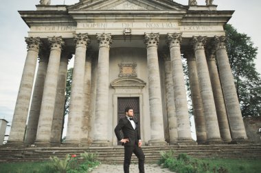 Arka plan eski kale üzerinde poz şık damat