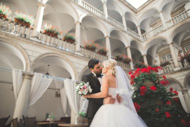 Güzel, mutlu bir düğün çifti, güzel şehirde uzun beyaz elbiseli bir gelin.