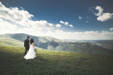 Güzel düğün çift, gelin ve damat, arka planda dağların aşık