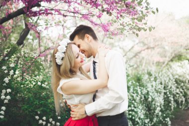 Şık güzel mutlu düğün çift öpüşme ve Botanik Bahçesi içinde kucaklayan