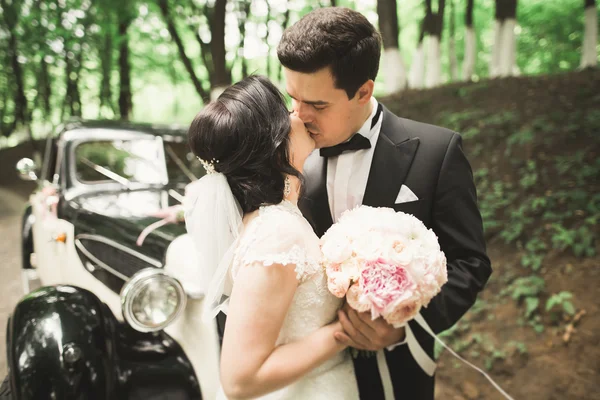 Casal de casamento perfeito segurando buquê de luxo de flores — Fotografia de Stock