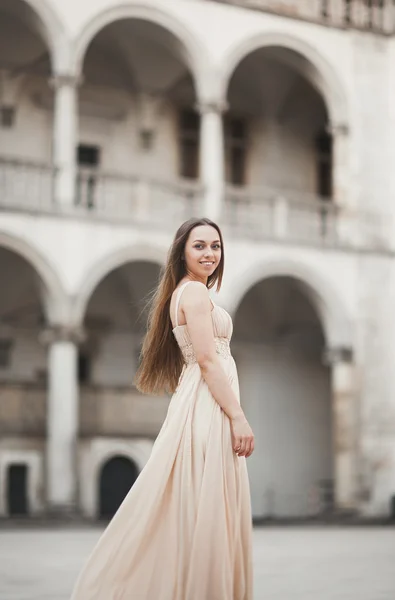 Piękna dziewczyna, model z długimi włosami pozowanie w starym zamku w pobliżu kolumn. Vavel Kraków — Zdjęcie stockowe