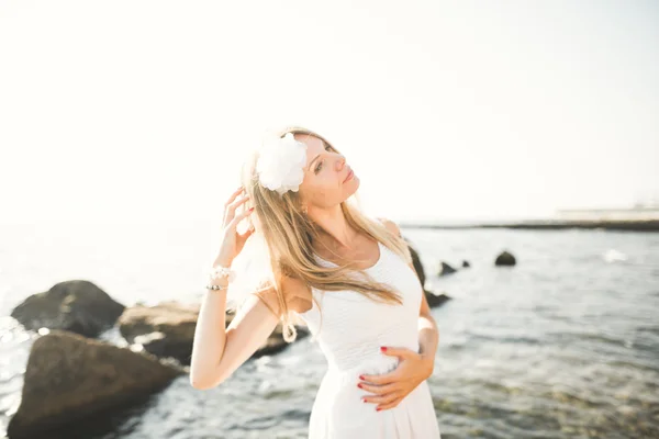 Beyaz elbiseli deniz taşları üzerine poz romantik güzel gelin — Stok fotoğraf