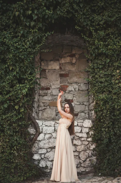 Hermosa chica, modelo cerca de la pared de hojas y arbustos en el parque — Foto de Stock