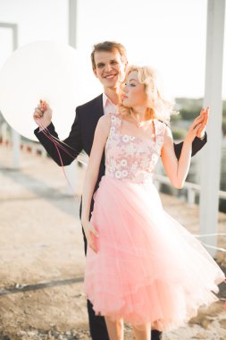 Çatıda mükemmel şehir manzaralı elele ve sarılma poz aşık genç bir çift. Güzel gün batımı