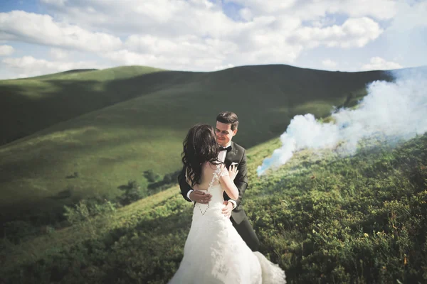 Jeune couple nouvellement marié, embrasser mariée et marié, embrasser sur une vue parfaite sur les montagnes, ciel bleu — Photo