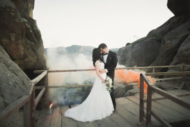 Muhteşem gelin, damat öpüşme ve sarılma Gösterim çarpıcı uçurum yakın: