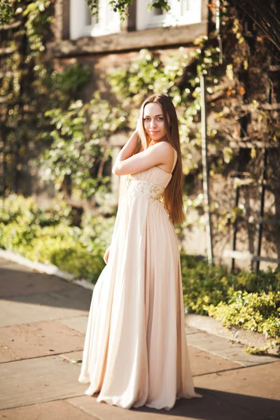 Atractiva joven con vestido largo disfrutando de su tiempo al aire libre en el fondo del atardecer del parque —  Fotos de Stock