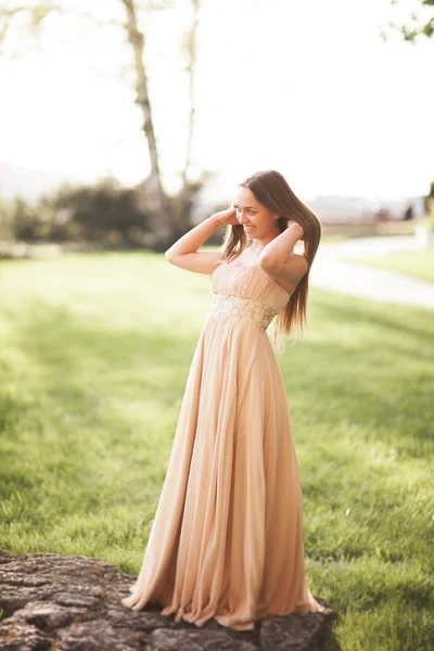 Attraktive junge Frau mit langem Kleid genießt ihre Zeit draußen im Park Sonnenuntergang Hintergrund — Stockfoto
