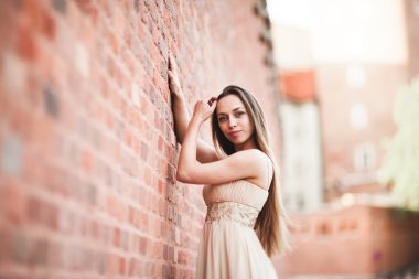 Uzun saç ve elbise mükemmel şekli tabaklanmış vücut possing duvarının yakınında güzel seksi kız