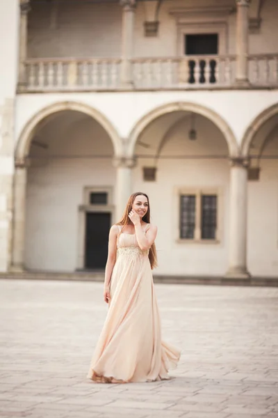 Menina bonita, modelo com cabelos longos posando em castelo velho perto de colunas. Cracóvia Vavel — Fotografia de Stock