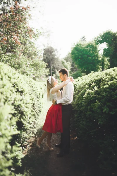 Όμορφο ζευγάρι φιλί και αγκαλιάζει κοντά σε δέντρα με άνθος σε πάρκο καλοκαίρι — Φωτογραφία Αρχείου