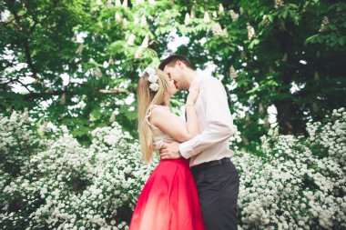 Şık güzel mutlu düğün çift öpüşme ve Botanik Bahçesi içinde kucaklayan