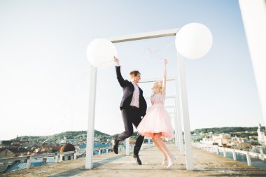 Sevgi dolu çift atlama ve eski şehir'in backgrounf ile çatı üzerinde gülümseyen