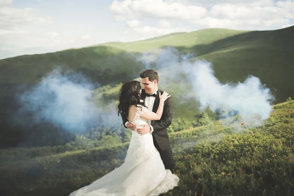 Красива весільна пара цілується і обіймається біля гори з ідеальним видом — стокове фото