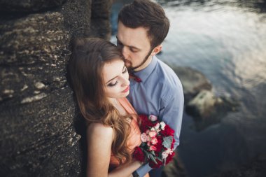 Mavi Denizi çevresinde büyük bir taş üzerinde oturan Düğün çifti