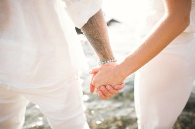 Gelin ve damat el ele tutuşuyor.