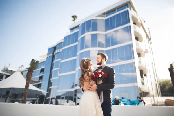 Eleganta vackra par poserar nära moderna glasbyggnad — Stockfoto