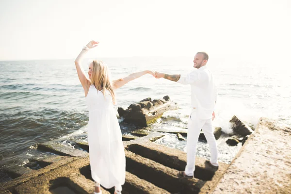 Feliz recém-casado jovem casal de casamento celebrando e se divertir no belo pôr do sol da praia — Fotografia de Stock