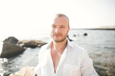 yakışıklı model adam taş denizin kenarında poz