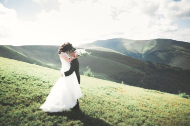 Öpüşen düğün çifti güzel manzarada kalıyor.