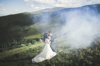 Güzel düğün çift, gelin ve damat, arka planda dağların aşık