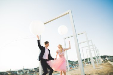 Sevgi dolu çift atlama ve eski şehir'in backgrounf ile çatı üzerinde gülümseyen