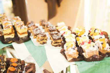 Çeşitli lezzetli tatlılar, yemek fikirleri ve kutlamalarla dolu bir büfe.