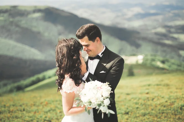 Linda noiva linda posando para noivo e se divertindo, cerimônia de luxo em montanhas com vista incrível, espaço para texto, casal de casamento — Fotografia de Stock