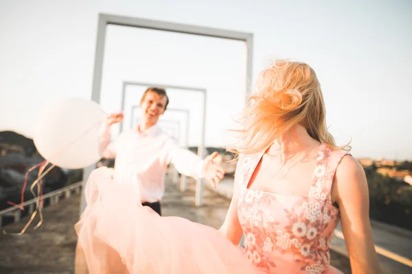 Moda lindo casal bonito posando no telhado com fundo da cidade. Jovem e sensual loira ao ar livre. Estilo de vida . — Fotografia de Stock