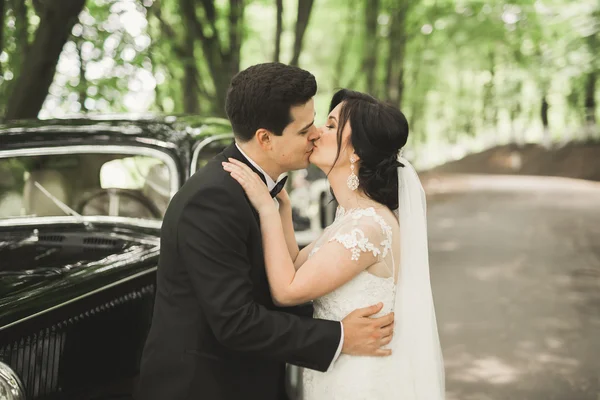 검정 자동차 근처에서 찍은 아름다운 신혼 부부 — 스톡 사진