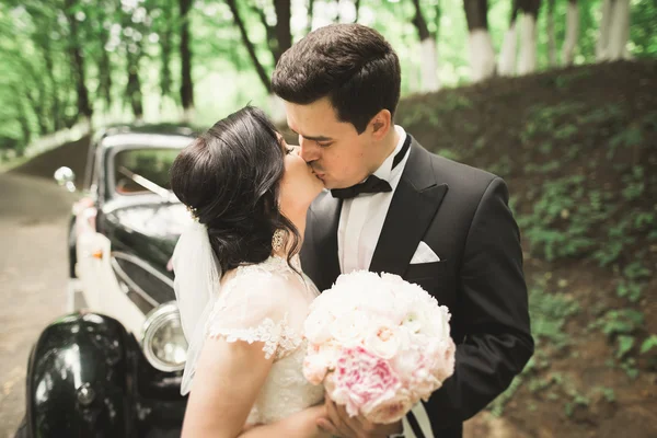 Casal de casamento perfeito segurando buquê de luxo de flores — Fotografia de Stock
