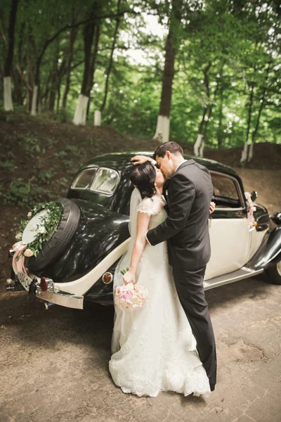 행복 한 신혼 부부, 남자와 아내 세련 된 레트로 자동차 근처 키스 — 스톡 사진