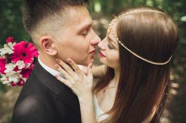 Genç ve güzel bir çift parkta öpüşüyor ve gülümsüyor.