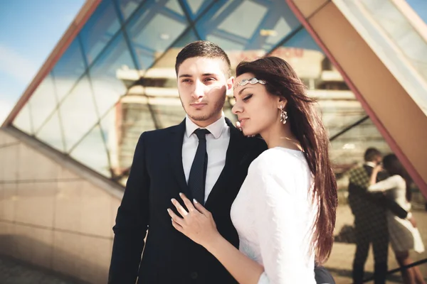 Stylish loving couple kissing and hugging near modern building — Stock Photo, Image